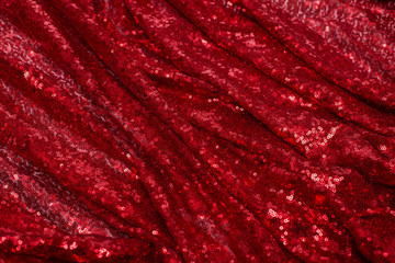 bright red fabric with small round sequins, with metallic sheen laid out by waves for Valentine's day