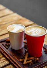 Two cups of cappuccino coffee with latte art on woden table background
