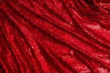 bright red fabric with small round sequins, with metallic sheen laid out by waves for Valentine's day