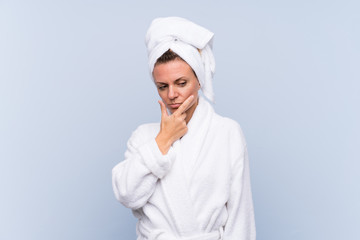 Woman in bathrobe over isolated blue background thinking an idea