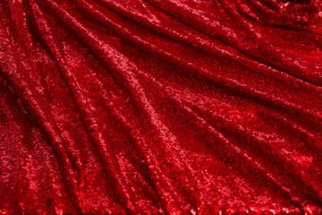 bright red fabric with small round sequins, with metallic sheen laid out by waves for Valentine's day