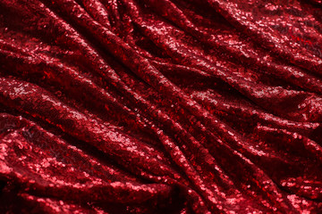 bright red fabric with small round sequins, with metallic sheen laid out by waves for Valentine's day