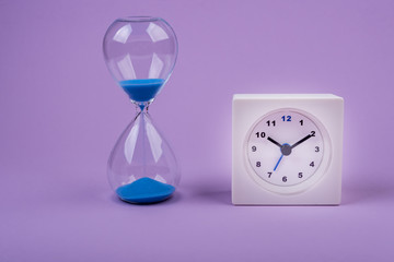 hourglass measuring the time  on a purple background