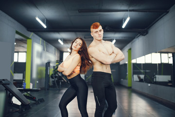 Fototapeta na wymiar Guy and girl in the gym. A boy and girl perform exercises. Sports people in the gym