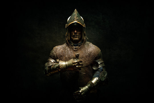 Portrait of a knight in armor holding his sword in his hands