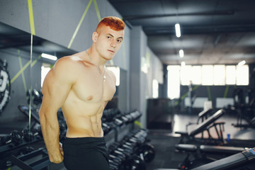 Fototapeta na wymiar Man in the gym. Muscular guy.Man performs exercises