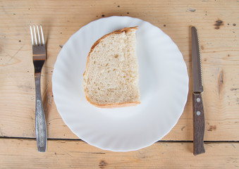 A slice of bread on a plate with a fork and knife