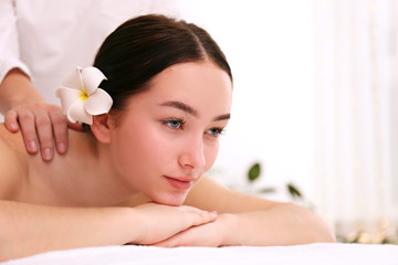 Obraz na płótnie Canvas Portrait young beautiful woman lying on the massage table in spa wellness salon. Beauty and health procedures for women concept. Close up, copy space, background.