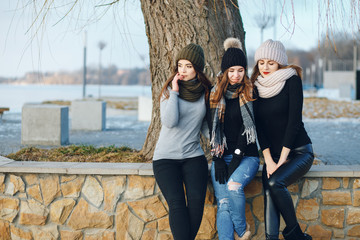 young and stylish three girls have fun in a winter park