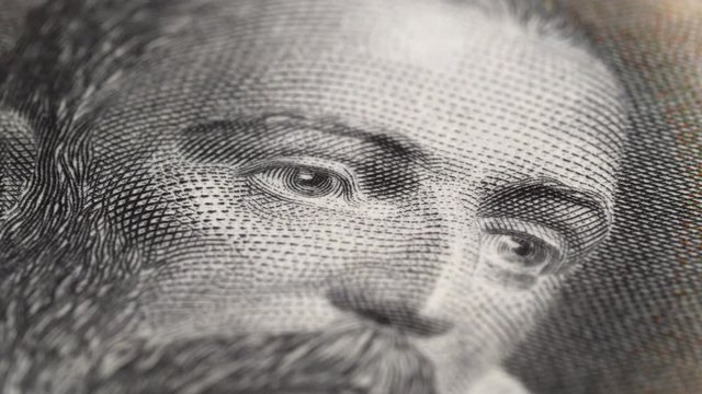 Miguel de Cervantes portrait on Spain 100 pesetas banknote (1928) rotating. Famous Spanish writer. Low angle, macro. 4K, 422 10 bit