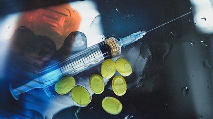 Syringe with a drug substance and drug pills.