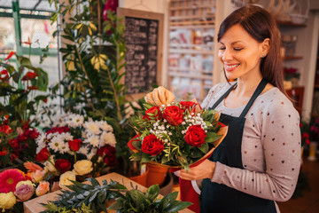 Happy florist holding beautifully decorated bouquet, portrait.