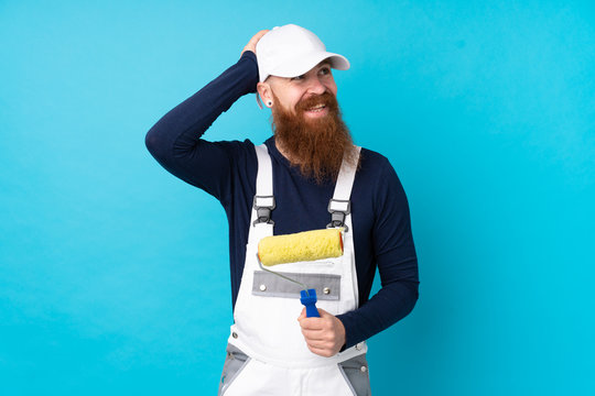 Painter man with long beard over isolated blue background laughing
