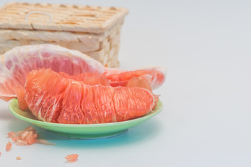 The red flesh of the red flesh pomelo and a basket are isolated on a white background.