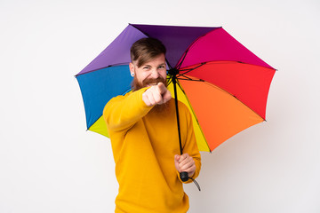 Redhead man with long beard holding an umbrella over isolated white background