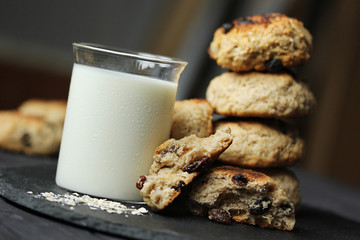 Cookies with raisins and milk on a dark wooden background. Fitness dessert