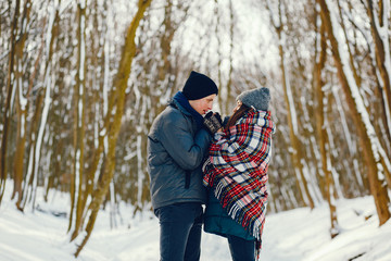 Fototapeta na wymiar Young and loving couple walking in a winter park