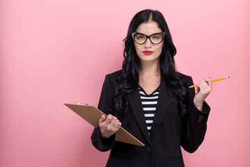 Office woman with a clipboard on a pink background