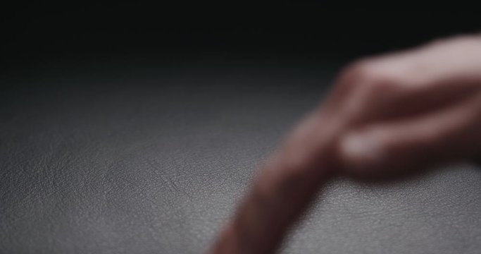 Slow motion man hand touching soft leather cushion