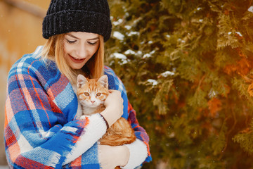 Fashion girl in a winter city. Lady with little cat