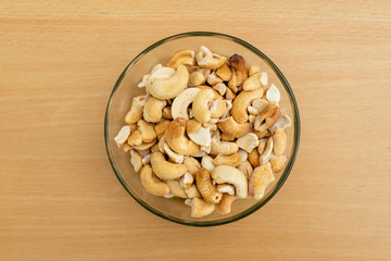 Top view cashews in the transpatent bowl on the wooden table