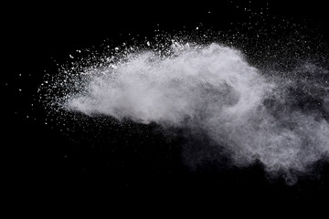 Freeze motion of white color powder exploding on dark background. 