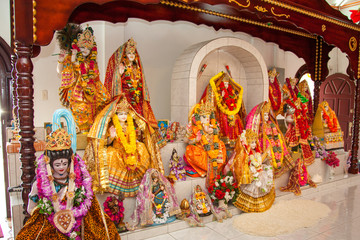 Colorful Hindu gods hung with flowers in a Hindu temple. World tourism, wedding, marriage.