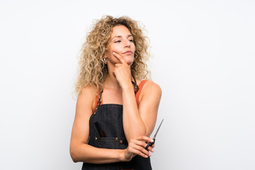 Young hairdresser woman over isolated background thinking an idea