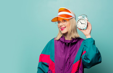 Beautiful woman in 90s sport suit with alarm clock