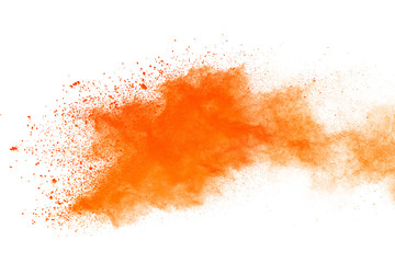 Abstract orange powder explosion. Closeup of orange dust particle splash isolated on white background.