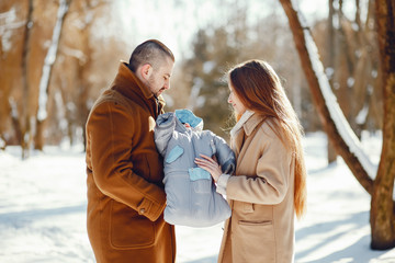Elegant family in a winter forest. Mother with little son. Man in a brown coat