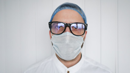 Young male surgeon dentist doctor in uniform is looking at camera, white background. Healthcare, medical education, emergency medical service and surgery concept