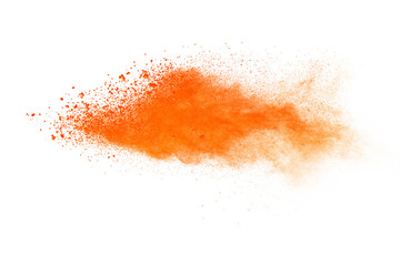 Abstract orange powder explosion. Closeup of orange dust particle splash isolated on white background.