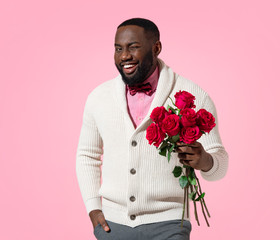 Handsome man holds bouquet of roses. Photo of african american man expresses love to someone,...
