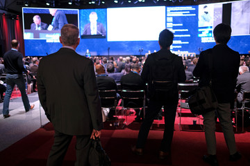 Audience members at a conference follow the presentation on stage