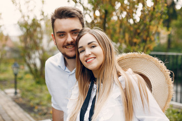 Obraz premium Cute couple in a park. Lady in a white dress. Guy in a white shirt
