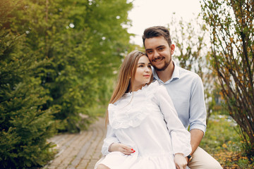 Obraz premium Cute couple in a park. Lady in a white dress. Guy in a white shirt