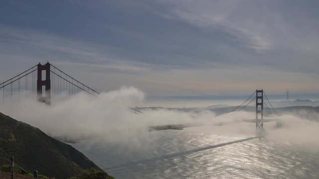 A time-lapse of the fog rolling under and over the Golden Gate Bridge showing the San Francisco skyline 