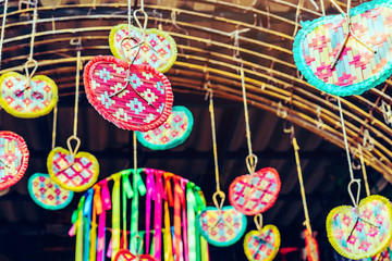 Many colorful of fanning woven from bamboo are hung above to decorate the walkway in the annual happiness festival in public park. Selective focus.