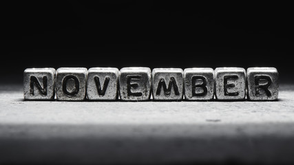 Volumetric inscription november silver metal cubes on a dark black background. Deadline calendar, personal scheduling and time management