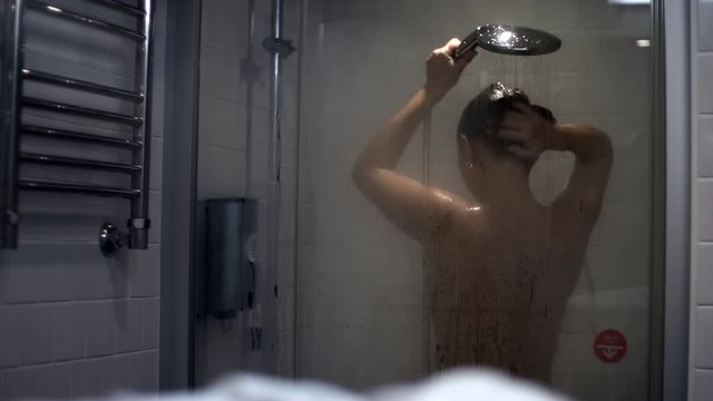 A woman washes her head Focus on water drops Slow motion.