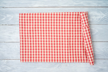 Red checked tablecloth on rustic wooden table. Kitchen, cooking or baking mock up background for design.