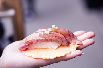 Hida beef sushi on rice cracker in Takayama old town, Japan.