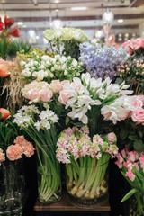 Flower shop concept. Different varieties fresh spring flowers in refrigerator room for flowers. Bouquets on shelf, florist business