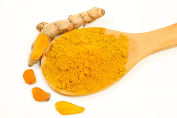 Turmeric powder in a wooden spoon and turmeric root extracted on a white background, used as a tonic for the body and food ingredients.