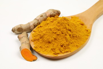 Turmeric powder in a wooden spoon and turmeric root extracted on a white background, used as a...