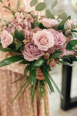 Female professional florist prepares the arrangement of wild flowers. Flower shop. Florist at work