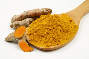 Turmeric powder in a wooden spoon and turmeric root extracted on a white background, used as a...