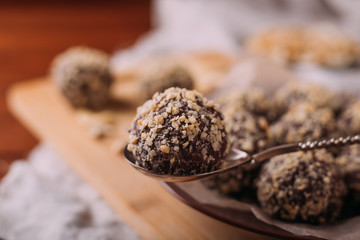 Cocoa balls, chocolate truffles cakes on board on wooden background
