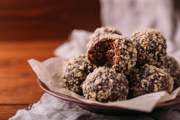 Cocoa balls, chocolate truffles cakes on board on wooden background